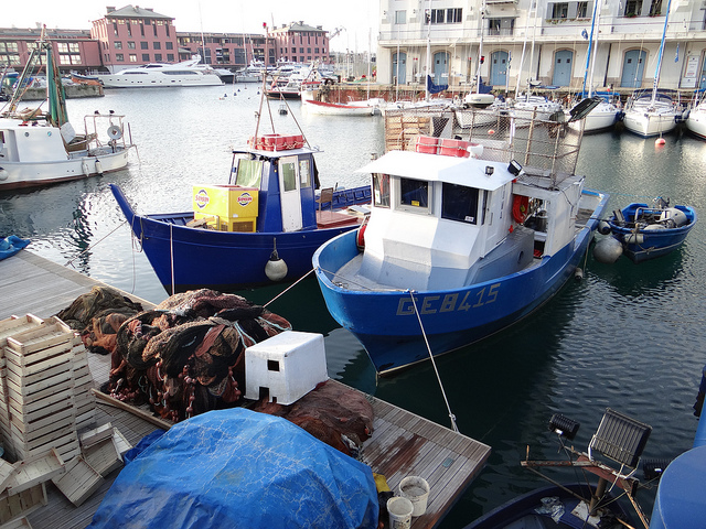 Fishing boats and mega yachts in Genoa Old Port Italy