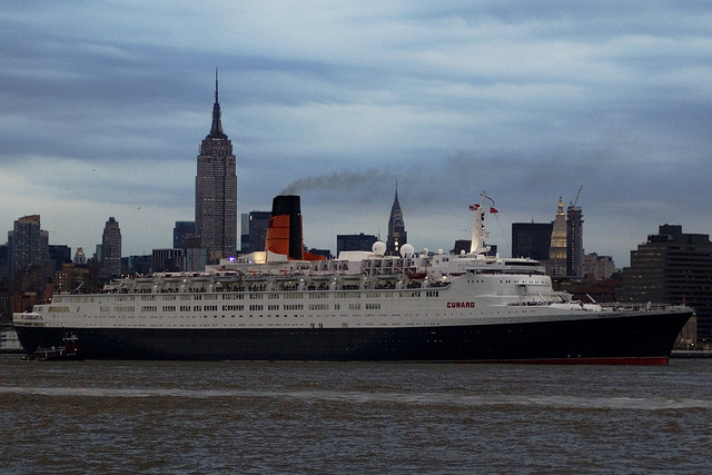 Cunard Queen Elizabeth 2 New York with the Empire State Building and the Chrysler Building in the background.