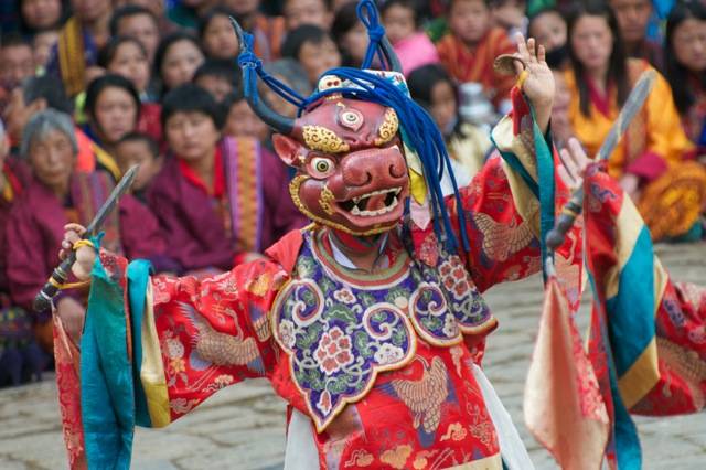 Masked dancers enact traditional dances