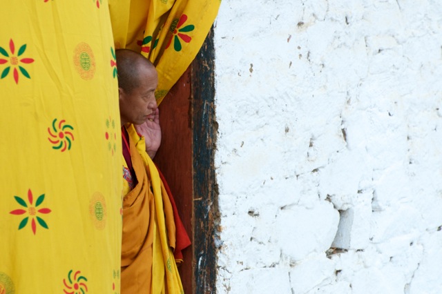 A monk peeping from inside the monastery to see the action