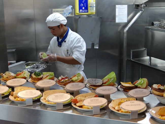 Chef on Holland America Nieuw Amsterdam prepares meals at the pool side grill