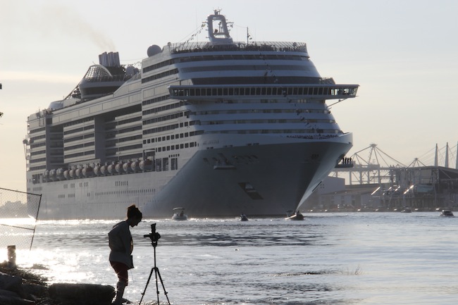 MSC Divina loomed large against one of the reporters on the bank
